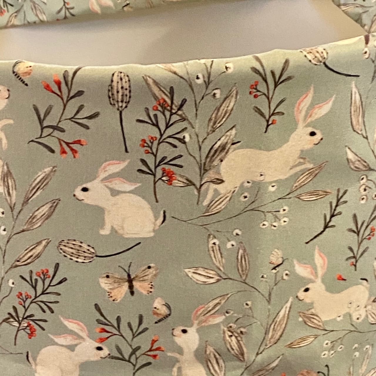 Fabric featuring small rabbits on a grey-blue background, view 3