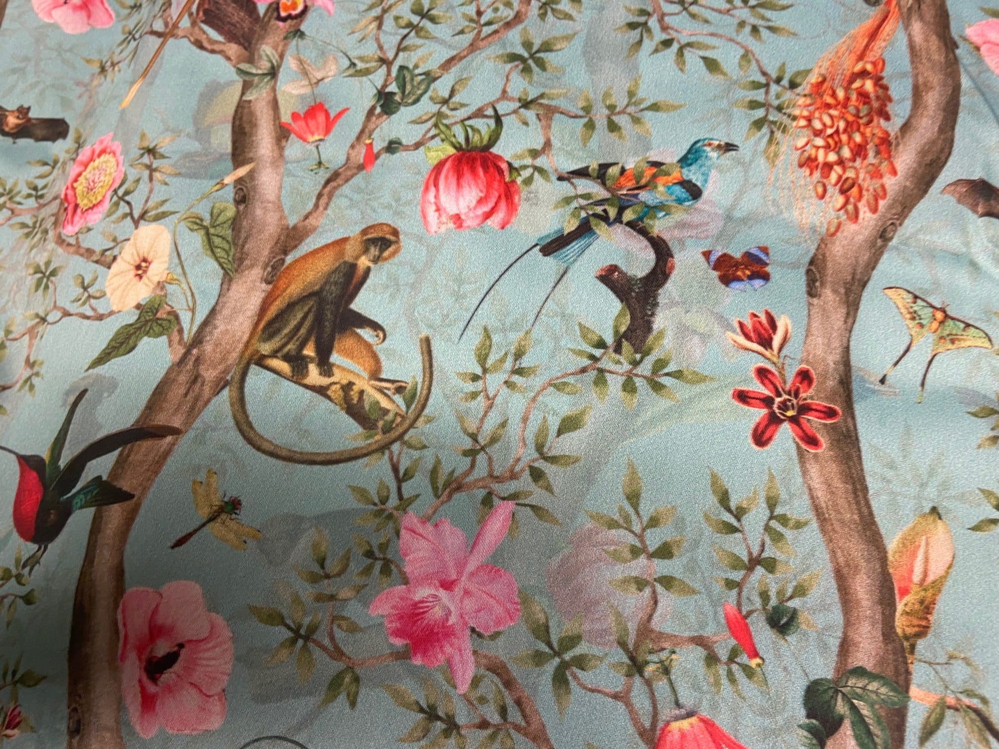 Fabric featuring hummingbirds and monkeys on a blue background, view 3